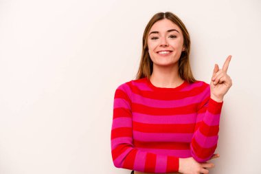 Beyaz arka planda izole edilmiş beyaz tenli genç bir kadın bir numarayı parmağıyla gösteriyor..