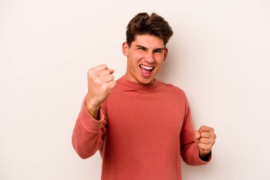 Beyaz arka planda izole edilmiş genç beyaz adam tasasız ve heyecanlı bir şekilde tezahürat yapıyor. Zafer konsepti.