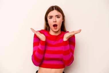 Beyaz arka planda izole edilmiş genç beyaz kadın şaşırmış ve şok olmuş..