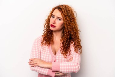 Beyaz arka planda izole edilmiş genç, beyaz, beyaz bir kadın. Kameraya alaycı bir ifadeyle bakıyor..