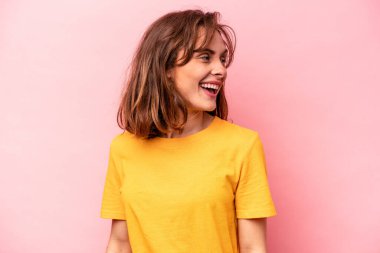 Pembe arka planda soyutlanmış beyaz bir kadın. Gülümsüyor, neşeli ve keyifli görünüyor..