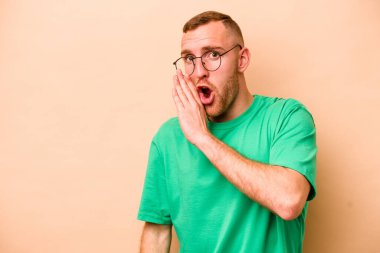 Beyazların arka planında izole edilmiş genç beyaz bir adam gizli bir sıcak fren haberinin olduğunu söylüyor.