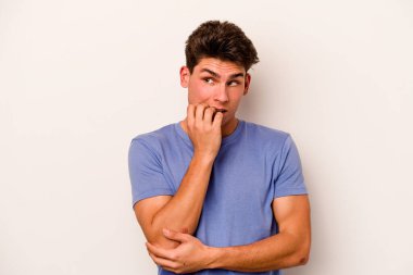 Beyaz arka planda izole edilmiş, tırnak yiyen, gergin ve endişeli genç bir beyaz adam..