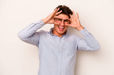 Beyaz arka planda izole edilmiş genç beyaz bir adam gözlerinde sorun olmadığını gösteriyor.