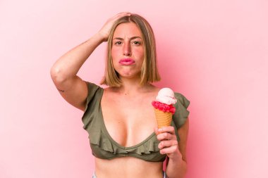 Bikini giyen ve elinde pembe arka planda izole edilmiş dondurma tutan beyaz bir kadın şok geçiriyordu. Önemli bir buluşmayı hatırladı..