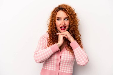 Beyaz arka planda izole edilmiş beyaz tenli genç bir kadın şans için dua ediyor, şaşırıyor ve ağzını açıyor..