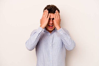 Beyaz arka planda izole edilmiş genç beyaz bir adam yüzünün yarısını palmiye ile örterek eğleniyor..