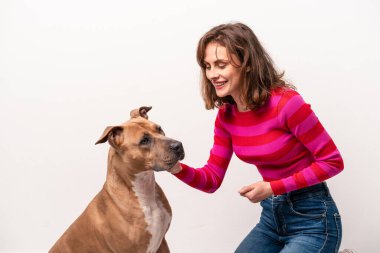 Beyaz arka planda köpeği olan beyaz bir kadın.