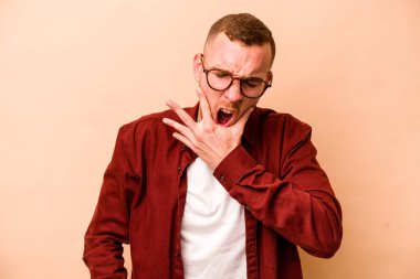 Beyazlı genç bir adam bej arka planda izole edilmiş güçlü bir diş ağrısı ve azı dişi ağrısı var..