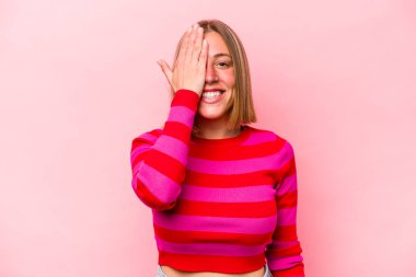 Pembe arka planda izole edilmiş beyaz bir kadın yüzünün yarısını palmiye ile örterek eğleniyor..