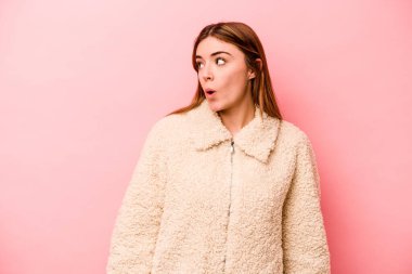 Pembe arka planda soyutlanmış beyaz bir kadın. Gülümsüyor, neşeli ve keyifli görünüyor..