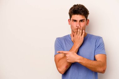Beyaz arka planda izole edilmiş genç beyaz adam yan tarafı işaret ediyor