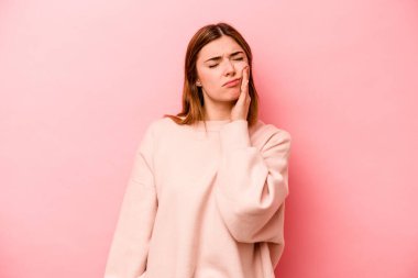 Pembe arka planda izole genç beyaz kadın güçlü bir diş ağrısı, azıdişi ağrısı var..