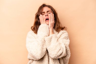 Beyaz tenli genç bir kadın bej arka planda izole edilmiş sızlanıyor ve ağlıyordu..