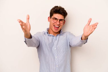 Beyaz arka planda izole edilmiş genç beyaz adam kameraya sarıldığı için kendinden emin hissediyor..