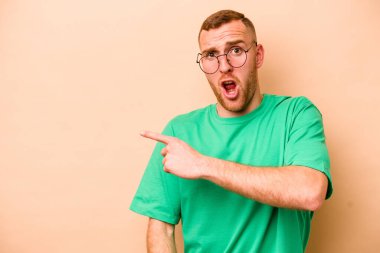 Beyazlı genç bir adam bej arka planda izole edilmiş.