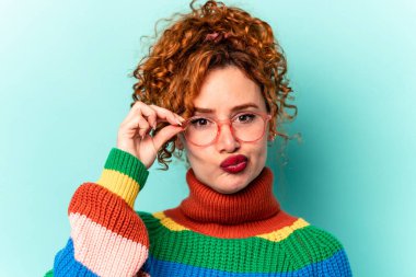 Mavi arka planda izole edilmiş genç kızıl beyaz kadın.