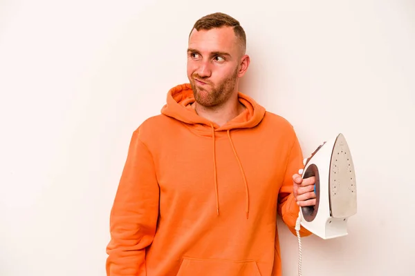 Young Caucasian Man Holding Iron Isolated White Background Confused Feels — Stock Photo, Image