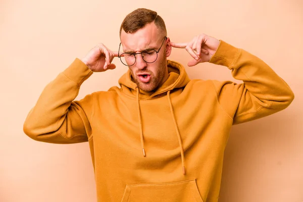 Young Caucasian Man Isolated Beige Background Covering Ears Fingers Stressed — Stock Photo, Image