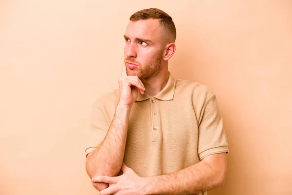 Young Caucasian Man Isolated Beige Background Contemplating Planning Strategy Thinking — Stock Photo, Image