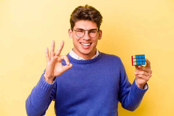 Mladý Kavkazský Muž Drží Rubiks Kostka Izolované Žlutém Pozadí Veselý — Stock fotografie