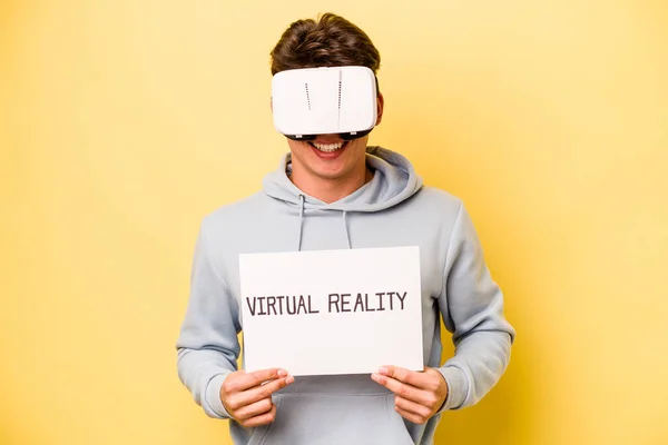 Jovem Caucasiano Segurando Cartaz Virtual Isolado Fundo Amarelo — Fotografia de Stock