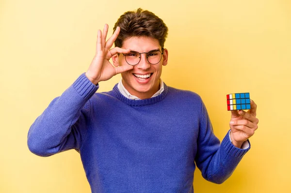 Mladý Běloch Drží Rubiks Kostka Izolované Žlutém Pozadí Vzrušený Udržet — Stock fotografie
