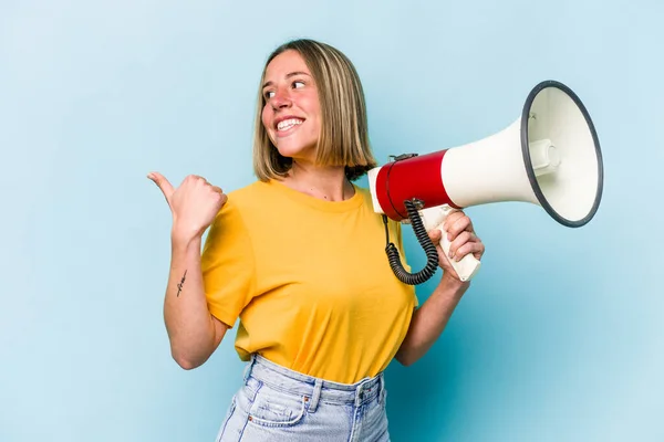 Young Caucasian Woman Holding Megaphone Isolated Blue Background Points Thumb — Stockfoto