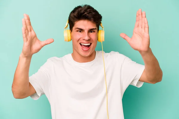 Giovane Uomo Caucasico Ascoltare Musica Isolata Sfondo Blu Ricevere Una — Foto Stock