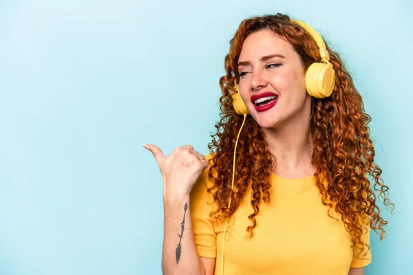Young Ginger Woman Listening Music Isolated Blue Background Points Thumb — Stock Photo, Image