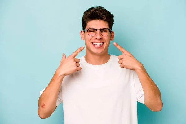 Jonge Blanke Man Geïsoleerd Blauwe Achtergrond Glimlacht Wijzende Vingers Naar — Stockfoto