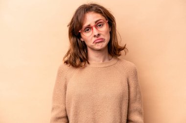 Beyaz tenli genç bir kadın bej arka planda izole edilmiş üzgün, ciddi yüzlü, mutsuz ve hoşnutsuz..