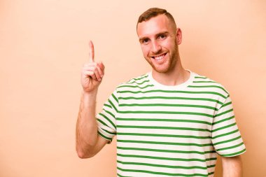 Beyazlı genç bir adam bej arka planda izole edilmiş. Parmak izi 1 numara..