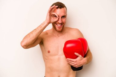 Beyaz arka planda boks yapan genç beyaz bir adam heyecanlı..