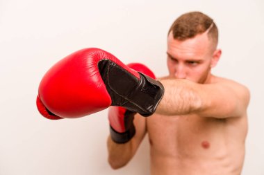 Beyaz arka planda boks yapan genç beyaz bir adam.