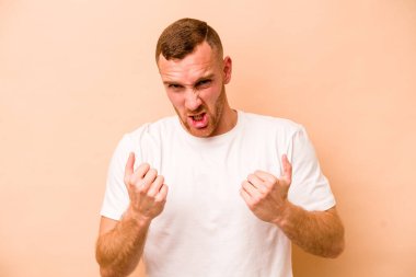 Beyazlı genç adam bej arka planda izole edilmiş gergin elleriyle çığlık atıyor..