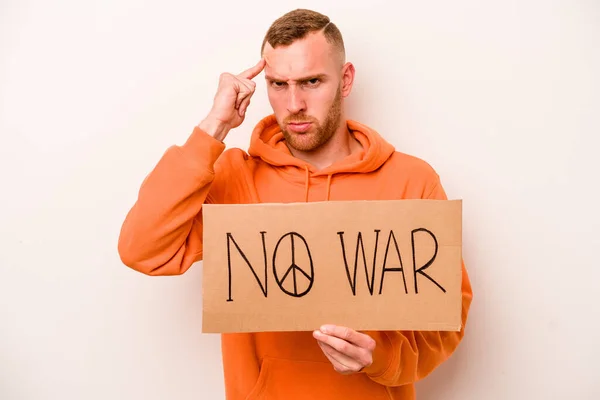 Young caucasian man holding no war placard isolated on white background