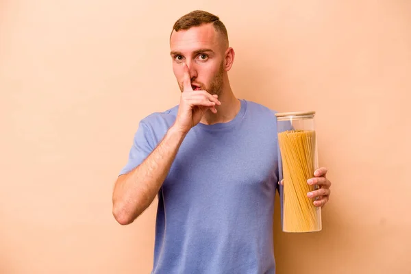 Young Caucasian Man Holding Spaghettis Jar Isolated Beige Background Keeping — Stock Photo, Image