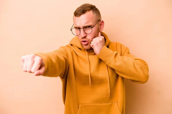 Young Caucasian Man Isolated Beige Background Throwing Punch Anger Fighting — Stock Photo, Image