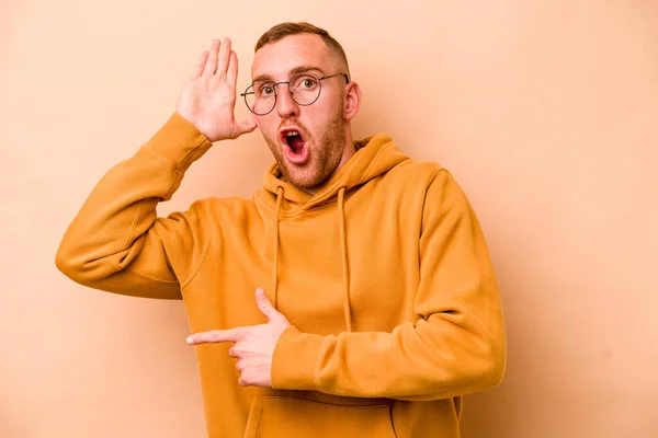 Young Caucasian Man Isolated Beige Background Trying Listening Gossip — Stock Photo, Image