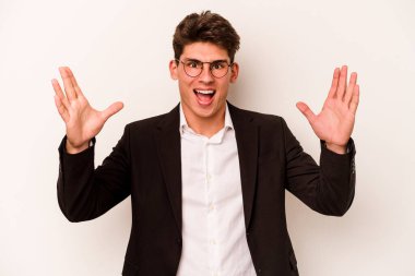 Beyaz arka planda izole genç beyaz iş adamı hoş bir sürpriz alıyor, heyecanlı ve el kaldırıyor..