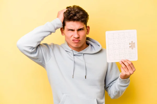 Giovane Uomo Caucasico Tenendo Puzzle Isolato Sfondo Giallo Essere Scioccato — Foto Stock