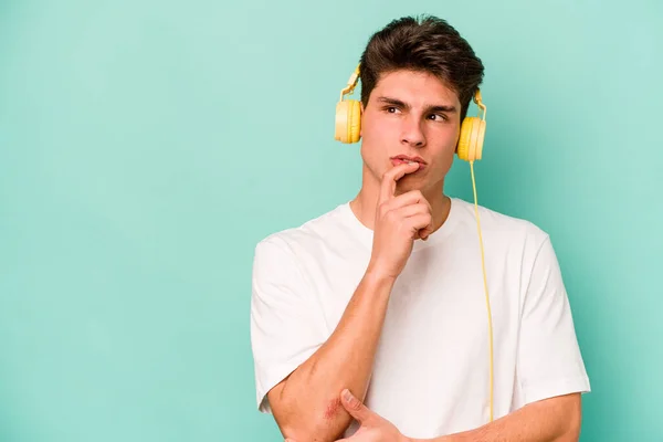 Jonge Blanke Man Luistert Naar Muziek Geïsoleerd Blauwe Achtergrond Ontspannen — Stockfoto