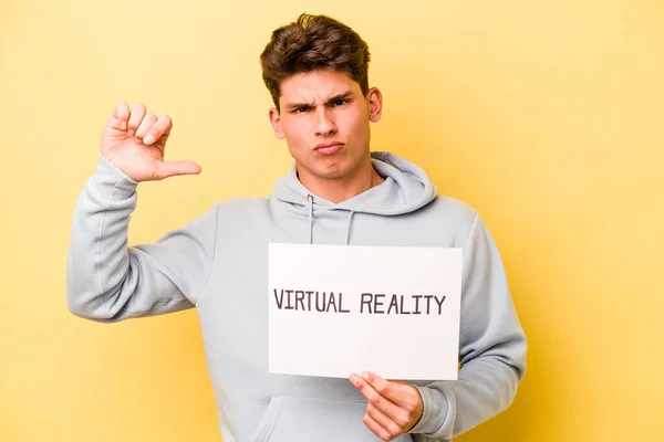 Jovem Caucasiano Segurando Cartaz Virtual Isolado Fundo Amarelo Sente Orgulhoso — Fotografia de Stock