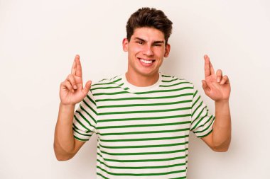 Beyaz arka planda izole genç beyaz adam şans dilemek için şans diliyor.