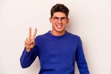 Beyaz arka planda izole edilmiş genç beyaz adam iki numarayı parmaklarıyla gösteriyor..