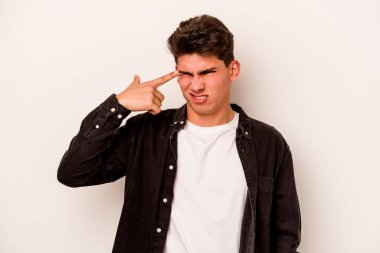 Beyaz arka planda izole edilmiş genç beyaz bir adam kulaklarını elleriyle kapatıyor..