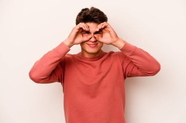 Beyaz arka planda izole edilmiş genç beyaz bir adam gözlerinde sorun olmadığını gösteriyor.