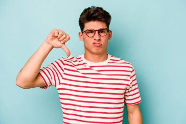 Mavi arka planda izole edilmiş genç beyaz bir adam hoşlanmadığı bir jest yapıyor. Anlaşmazlık konsepti.