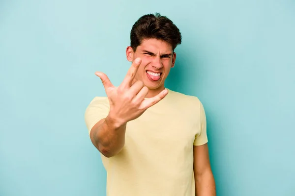 Νεαρός Καυκάσιος Άνδρας Απομονωμένος Μπλε Φόντο Που Δείχνει Ροκ Χειρονομία — Φωτογραφία Αρχείου